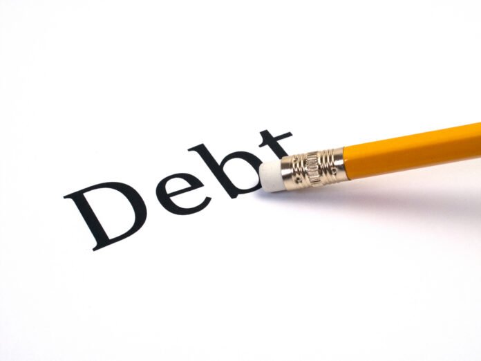 Second mortgages and foreclosure A piece of paper with Debt written on it, with a pencil's eraser pointing at the b in debt