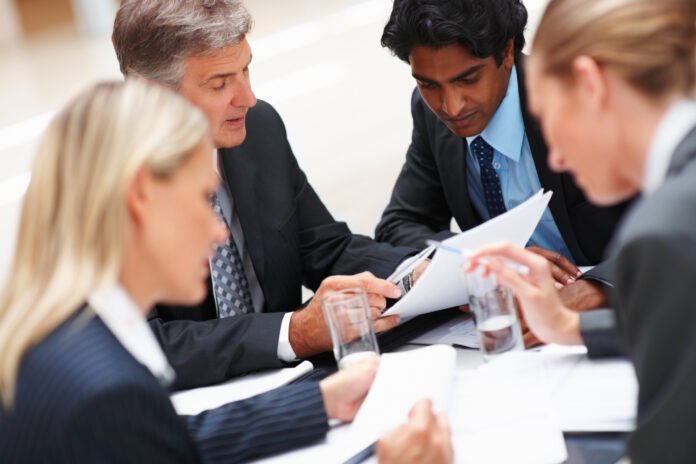 Setting up a Private Lending Business Group of business people sitting around a table looking at documents